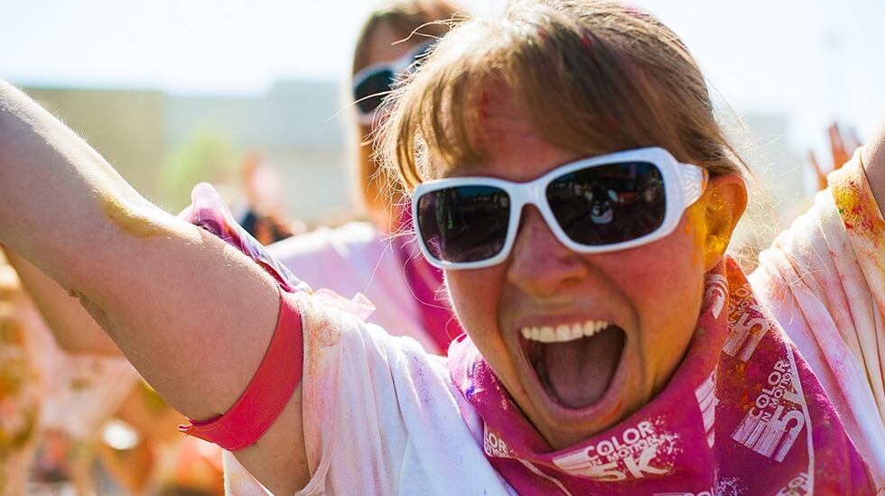 Woman is joyous as she does a colorful marathon for hope